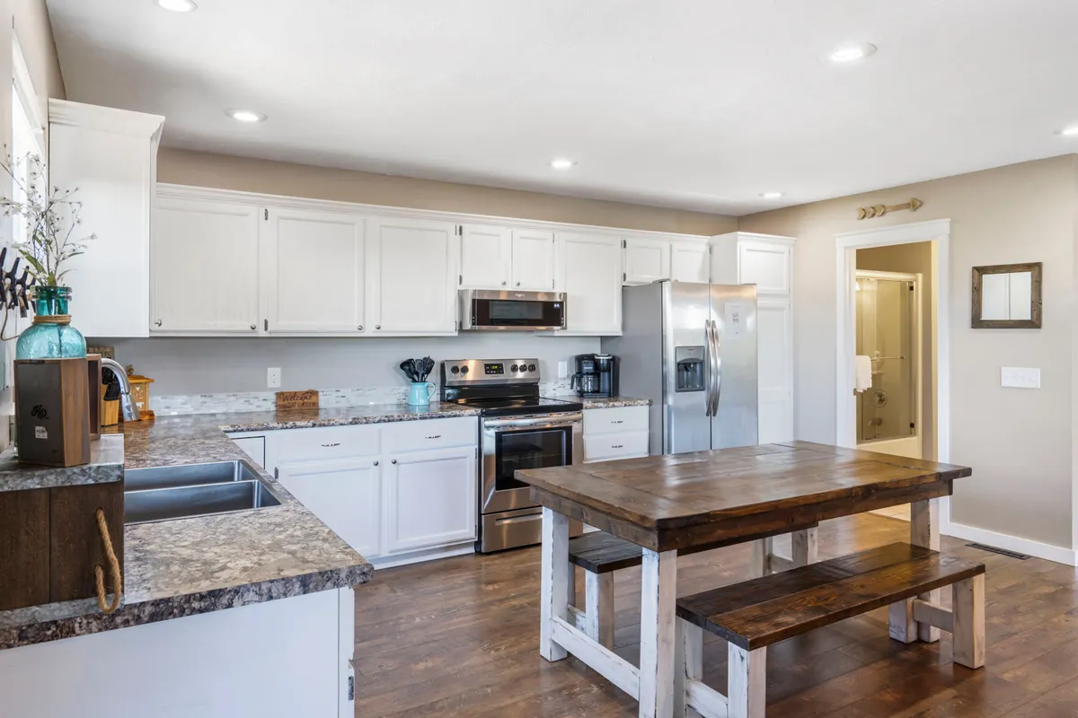 A bright, welcoming kitchen with a central island, stainless steel appliances, and a dining table adjacent. The space feels homey and ideal for preparing and sharing meals with loved ones.